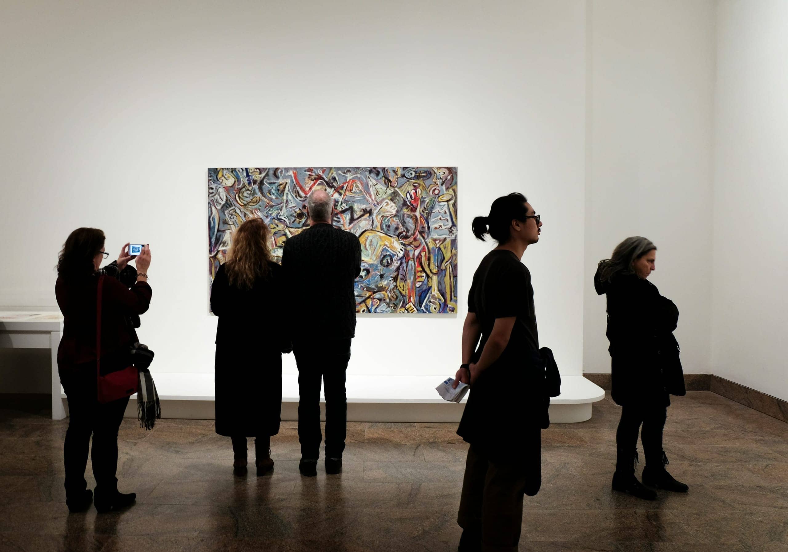 Visitors viewing a painting in a museum gallery